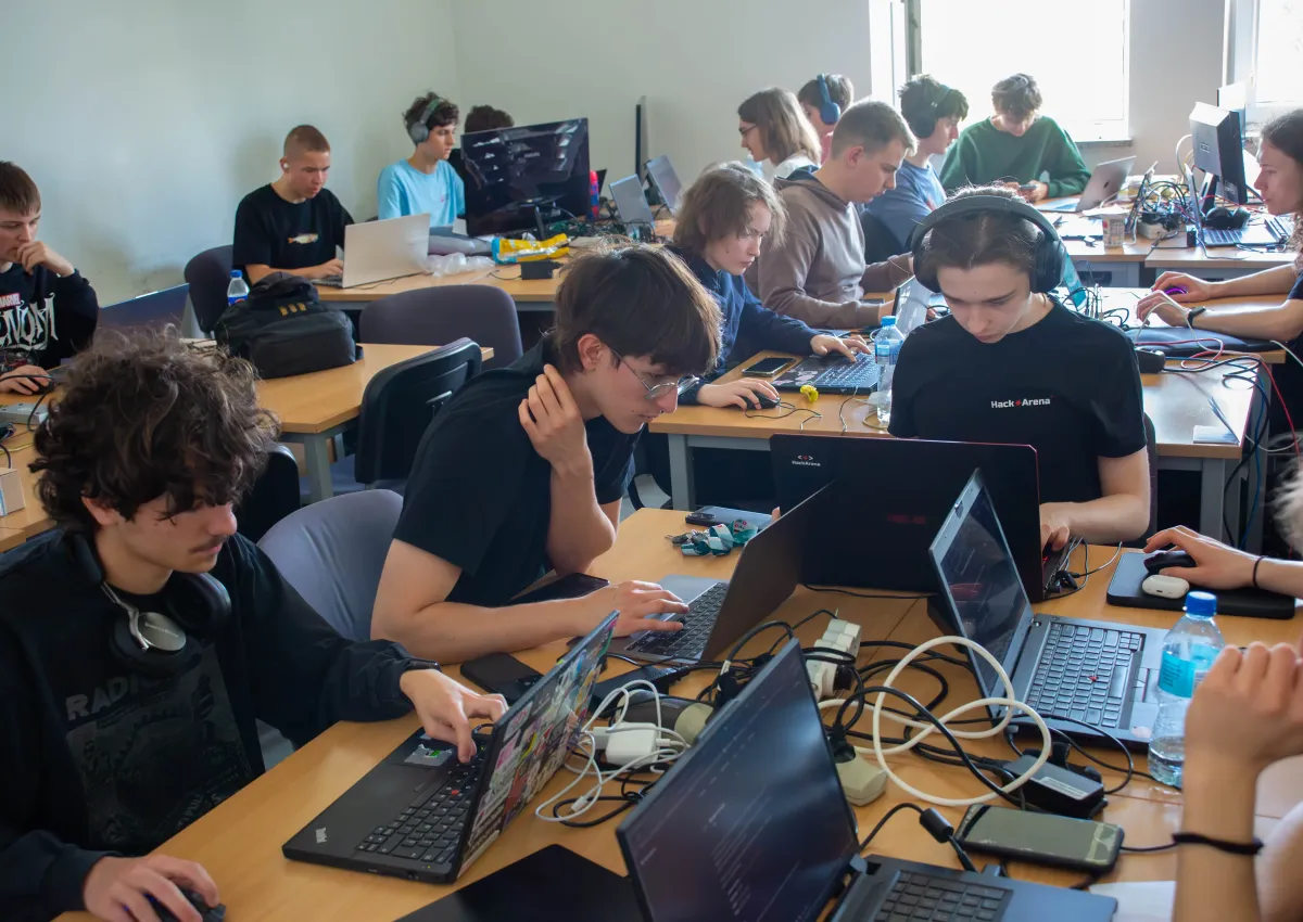 Uczestnicy wydarzenia technologicznego pracujący w grupie